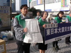 新宿駅西口で募金活動、購入 予定の土のう袋を持ってお願い
